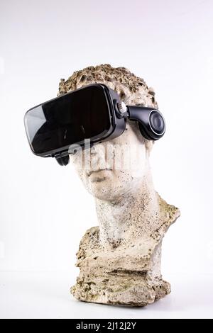 Ancient statue with VR glasses on white background. Concept of art and Virtual Reality. Stock Photo