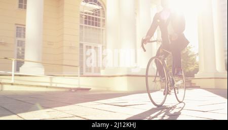 Everyone takes a different journey in life. Shot of an unrecognizable businessman commuting to work with his bicycle. Stock Photo