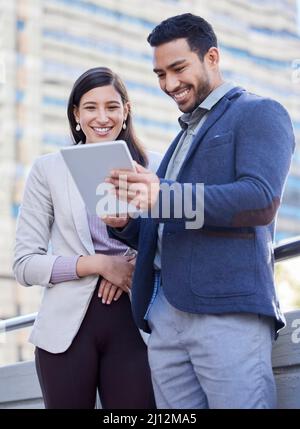 If we stay together well never fail. Shot of two coworkers using a digital tablet together. Stock Photo