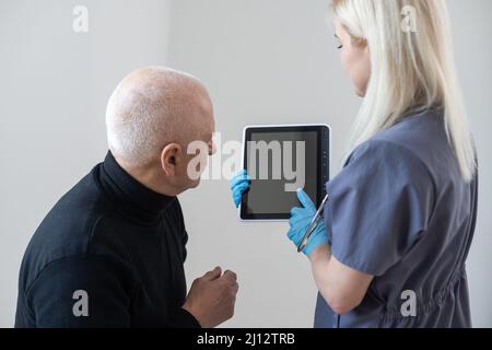 Portrait of smiling mature male patient feel excited about good quality service in private hospital. Happy senior 60s man satisfied with consultation Stock Photo
