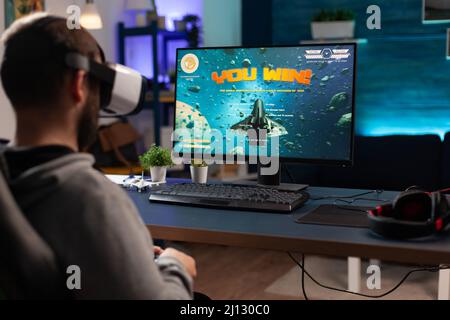 Free Photo  Gamer using controller to play online video games on computer.  man playing game with joystick and headphones in front of monitor. player  having gaming equipment, doing fun activity.