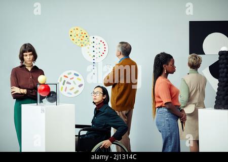 Group of diverse multi-ethnic people looking at various contemporary art objects at exhibition in modern museum Stock Photo