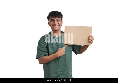 Young peruvian man smiling and pointing at a board, isolated. Stock Photo