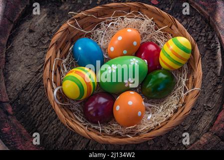colorful easter eggs in a braided basket with wooden wool, close up and isolated exposure Stock Photo