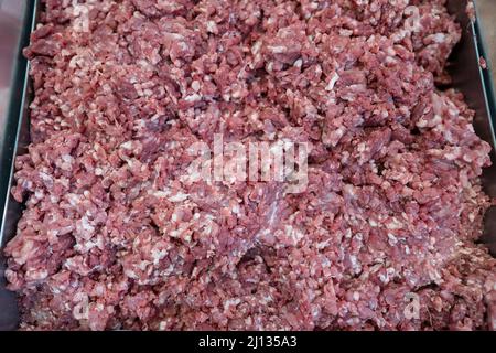 Close up fresh minced meat in the market, Thailand. Chopped meat through flesh grinder. Minced meat from fresh meat background in store Stock Photo