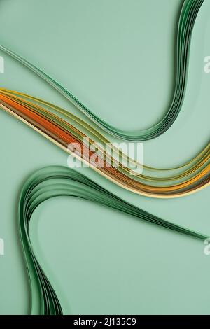 Green yellow and orange paper quilling background. Horizontal image. Paper stripes laid in waves Stock Photo