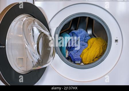 Colorful laundry inside a front loader washing machine Stock Photo