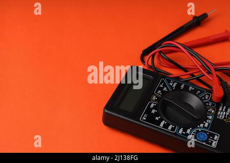 Multimeter on orange background, space for text Stock Photo