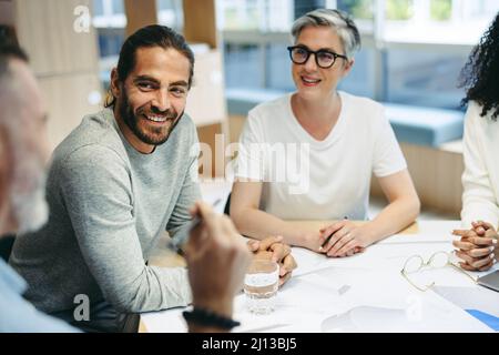 Happy design professionals having a discussion during a meeting in the office. Group of innovative businesspeople sharing creative ideas while working Stock Photo