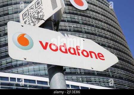 Düsseldorf (Vodafone campus) - March 9. 2022: View on arrow direction sign against modern tower and clear blue sky Stock Photo