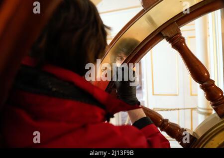 Student conservator Andrew Braund from West Dean College, cleans the helm of the Victorian battleship HMS Warrior at Portsmouth Historic Dockyard, as part of National Spring Cleaning Week. The conservation team have been researching and trialling a different way to treat the brass, using less abrasive techniques and a coating system that works well with the environment. Launched in 1860, HMS Warrior was Britain's first iron-hulled warship and had a lasting influence on naval architecture and design. Picture date: Tuesday March 22, 2022. Stock Photo