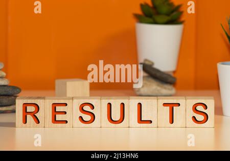 Businessman puts wooden blocks with the word Results. The concept of annual financial statements. Analysis of profits and revenues in the company. Ach Stock Photo