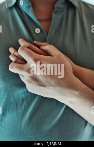 You make my heart skip a beat. Cropped shot of a man placing his girlfriends hand on his heart. Stock Photo