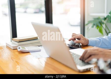 Business analyst concept the male freelancer checking for the sale of the selling trend on his devices. Stock Photo