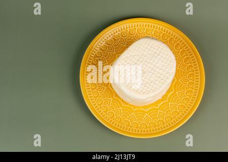 typical Brazilian Minas cheese from Minas Gerais on a yellow plate Stock Photo