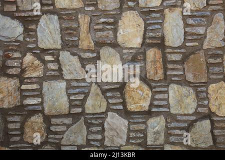 Symmetrical stone wall. Arranged in a perfect way.  Beautiful stone texture. Front view. Stock Photo
