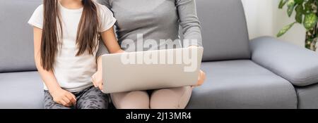 Helpful mother explaining to daughter about using a laptop Stock Photo