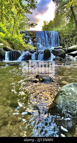 Vertical shot of a waterfall in a forest Stock Photo - Alamy