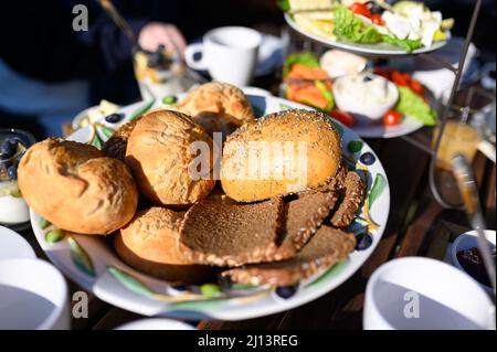 Hamburg, Germany. 05th Mar, 2022. A bowl of rolls and bread stands on a richly set breakfast table in the sunshine. Credit: Jonas Walzberg/dpa/Ģ����ý Live News Stock Photo