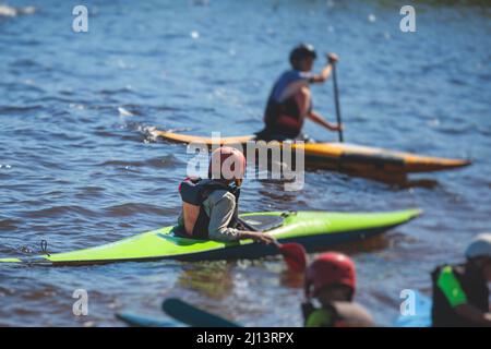 Kids learn kayaking, canoeing whitewater training in the lake river, children practicing paddling, young kayakers in a summer camp Stock Photo