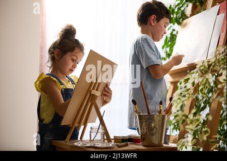 Pretty girl artist paints on canvas in art studio Stock Photo - Alamy