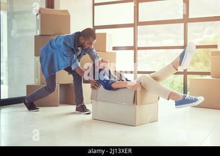 New beginnings.... Shot of a happy young couple having fun while moving into their new home. Stock Photo