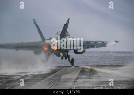 Philippine Sea, United States. 20 March, 2022. A U.S. Navy F/A-18E Super Hornet fighter jet, assigned to the Tophatters of Strike Fighter Squadron 14 fighter jet, launches off the flight deck of the Nimitz-class aircraft carrier USS Abraham Lincoln during routine operations, March 18, 2022 in the Philippine Sea.  Credit: MC3 Javier Reyes/Planetpix/Alamy Live News Stock Photo