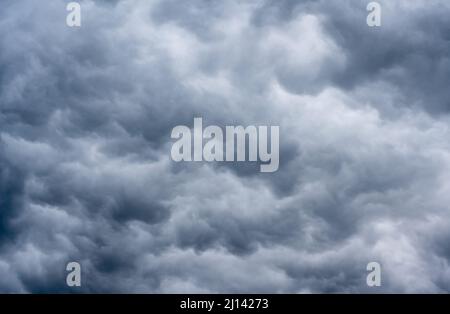 A dark cloudy sky announcing a thunderstorm offering different shades of gray. Stock Photo