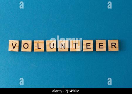 Volunteer background. Phrase from wooden letters. Top view words. The phrases is laid out in wood letter. Motivation. Stock Photo