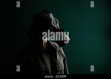 Photo of a military man in a gas mask, apocalypse, nuclear weapons, atomic explosion of a station, chemical and nuclear weapons protection. Girl in a Stock Photo