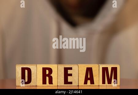 dream word abstract in vintage wood letterpress printing blocks with reflection in grunge silver surface. Stock Photo