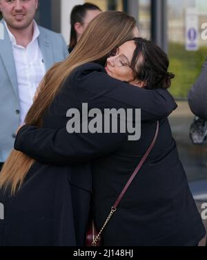 The family of Corrie McKeague, brother Daroch's partner Leah McElrea and sister-in-law Cloe McKeague embrace outside Suffolk Coroner's Court, Ipswich, Suffolk, following a verdict at the inquest into his death. The inquest jury recorded in a narrative conclusion that Mr McKeague died at approximately 4.20am in Bury St Edmunds as a result of 'compression asphyxia in association with multiple injuries'. Mr McKeague vanished on a night out in Bury St Edmunds on September 24 2016. Picture date: Tuesday March 22, 2022. Stock Photo