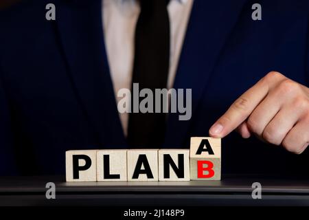 Time for Plan B. Hand is turning a dice and changes the word Plan A to Plan B. Stock Photo