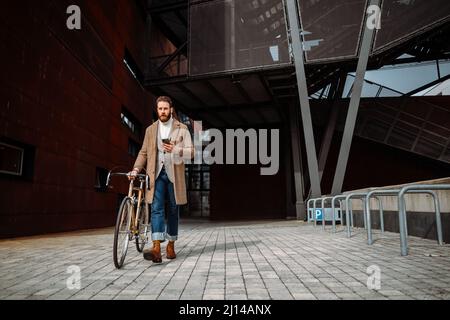 Businessman with bicycle going from work. Commuting. Male manager in business centre. Eco travel Stock Photo