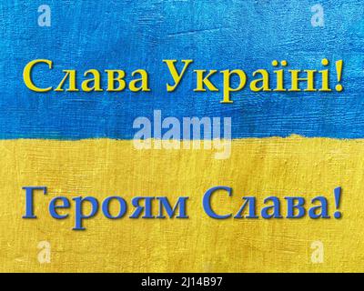 message Glory to Ukraine, Glory to Heroes in Ukrainian on flag painted on wall Stock Photo