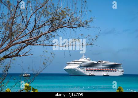 The view of Half Moon Cay tourist beach waters and a drifting cruise ship in a background (Bahamas). Stock Photo