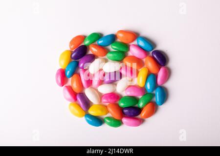Overhead view of multi colored candies arranged in circle over white background with copy space Stock Photo