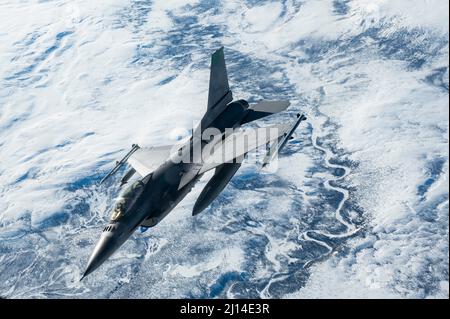 Central Alaska, United States. 16 March, 2022. A U.S. Air Force F-16 Fighting Falcon fighter jet, assigned to 180th Fighter Wing, banks away after refueling from a KC-135R Stratotanker during Operation Arctic Edge, March 16, 2022 over Alaska. The Northern Command Exercise is part of recent military moves to deter Russian involvement in Ukraine.  Credit: SSgt. Taylor Crul/U.S. Air Force/Alamy Live News Stock Photo