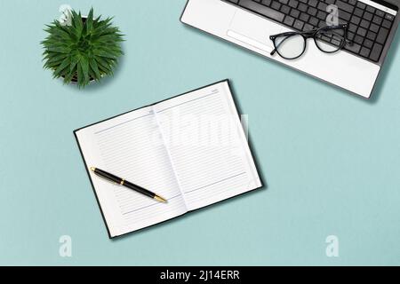 Office template. Laptop, glasses, notepad, pen and succulent on the mint color background. Mock up with copy space. Flat lay. Stock Photo