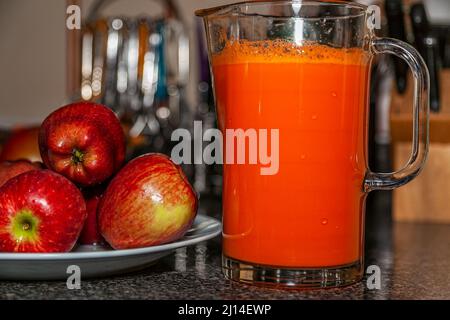 Healthy eating with apples on a plate and fresh fruit juice in a glass pitcher Stock Photo