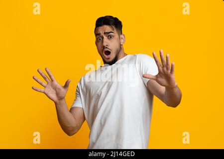 Scared arab guy in casual showing stop gesture Stock Photo