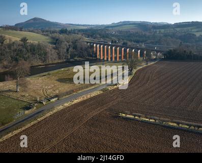 Aerial view to the site of Trimontium Roman fort complex by Newstead in the Scottish Borders. Amphitheatre in dip with shadow of tree. Stock Photo