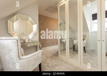 Changing room with fitted wardrobes in cream beige neutral colour scheme Stock Photo