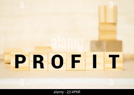 Businessman puts wooden blocks with the word Profit. The financial result of the company for a certain period of time. Income. Return on investment. P Stock Photo