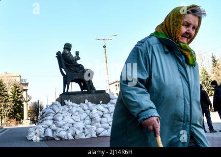 ZAPORIZHZHIA, UKRAINE - MARCH 22, 2022 - An elderly woman walks past the monument to Russian composer Mikhail Glinka surrounded by sandbags outside th Stock Photo