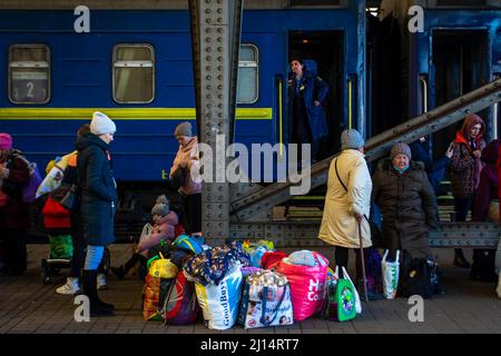 People with their luggage wait to board a train out of Ukraine. As the war in Ukraine continues people flee from the violence by train coming to Lviv or traveling on to Poland. Stock Photo