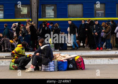 People wait to board a train to Poland. As the war in Ukraine continues people flee from the violence by train coming to Lviv or traveling on to Poland. Stock Photo