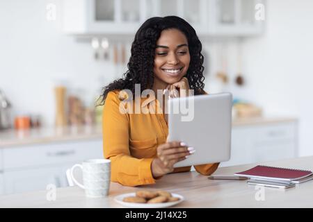Happy black woman using digital tablet and having coffee break Stock Photo