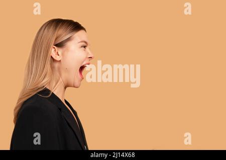 Young business woman screaming loud side view isolated on color background. Caucasian female business person aggressive yelling. Business woman shouti Stock Photo
