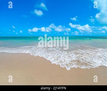 Beautiful landscape with the sea water hitting the sand of the beach calmly on a beautiful sea beach in cyan tones on a beautiful blue sky day. Barra Stock Photo